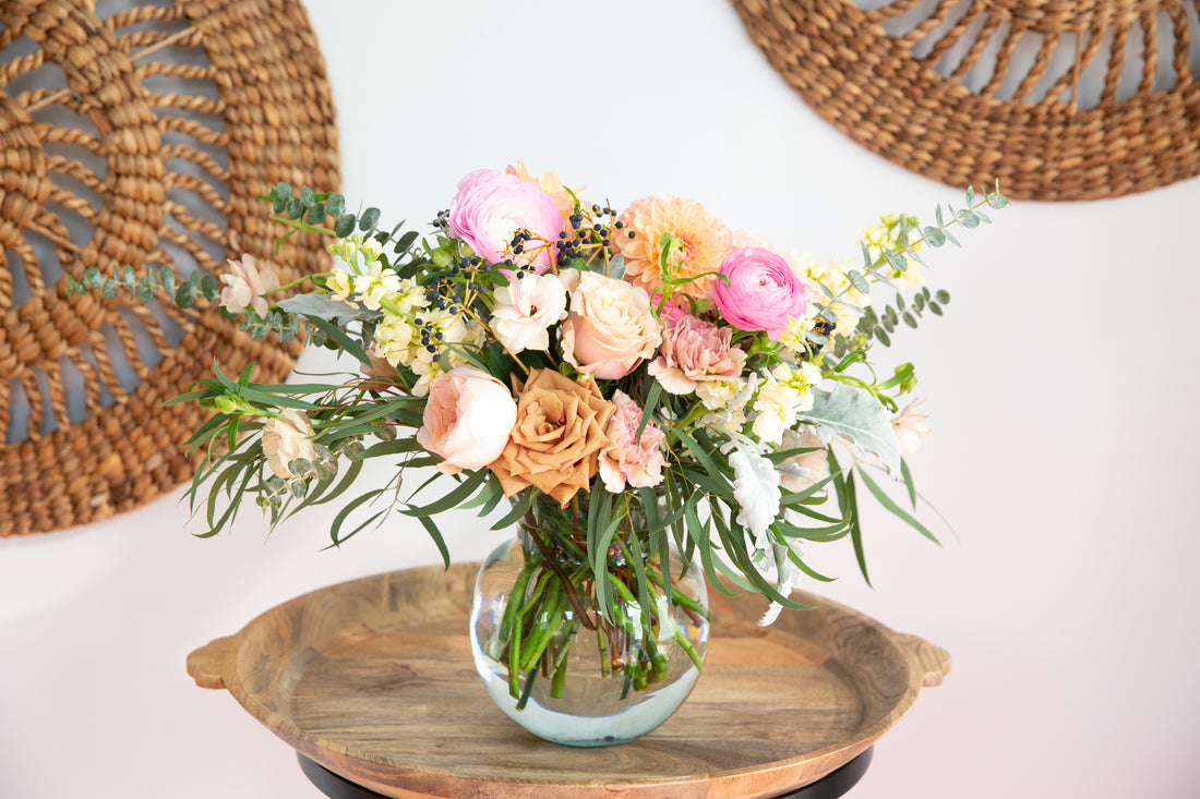 An arrangement of wild flowers in a recycled glass vase