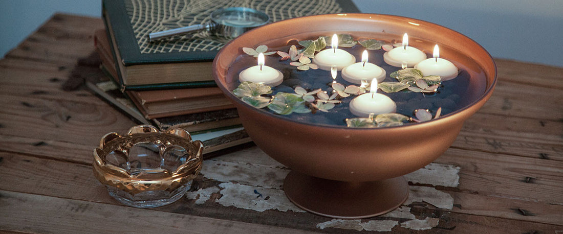 rose gold footed bowl with floating candles and petals