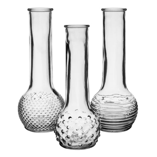 A set of three empty glass bud vases with textured designs; one with a dotted pattern, another with a dashed pattern, and the third with a striped pattern, displayed against a white background.
