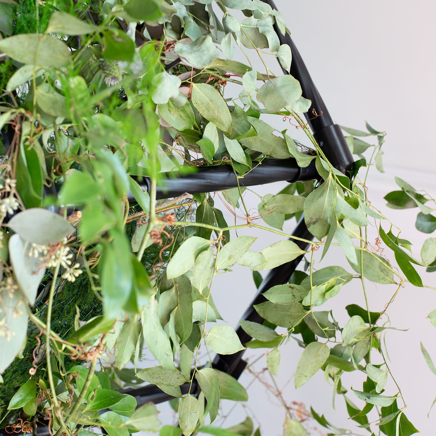 Hexagon Wedding arch covered in flowers and plants.