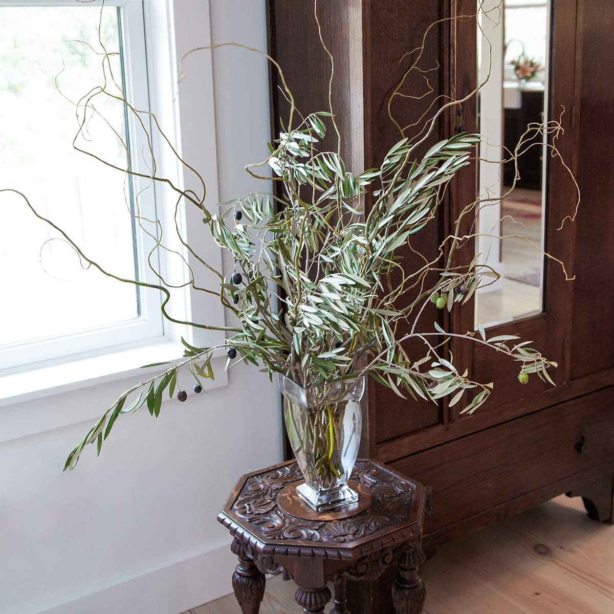 large regal vase filled with olive branches and curly willow